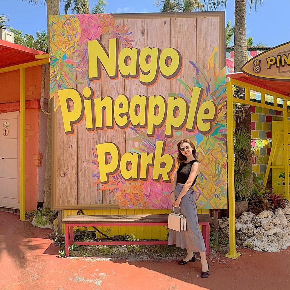 ナゴパイナップルパークの入り口に立つ女性