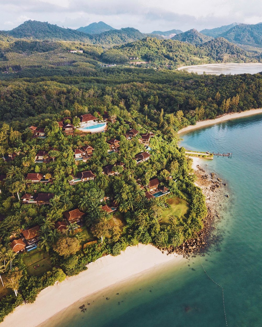 Hotel with a white sand beach surrounded with nature