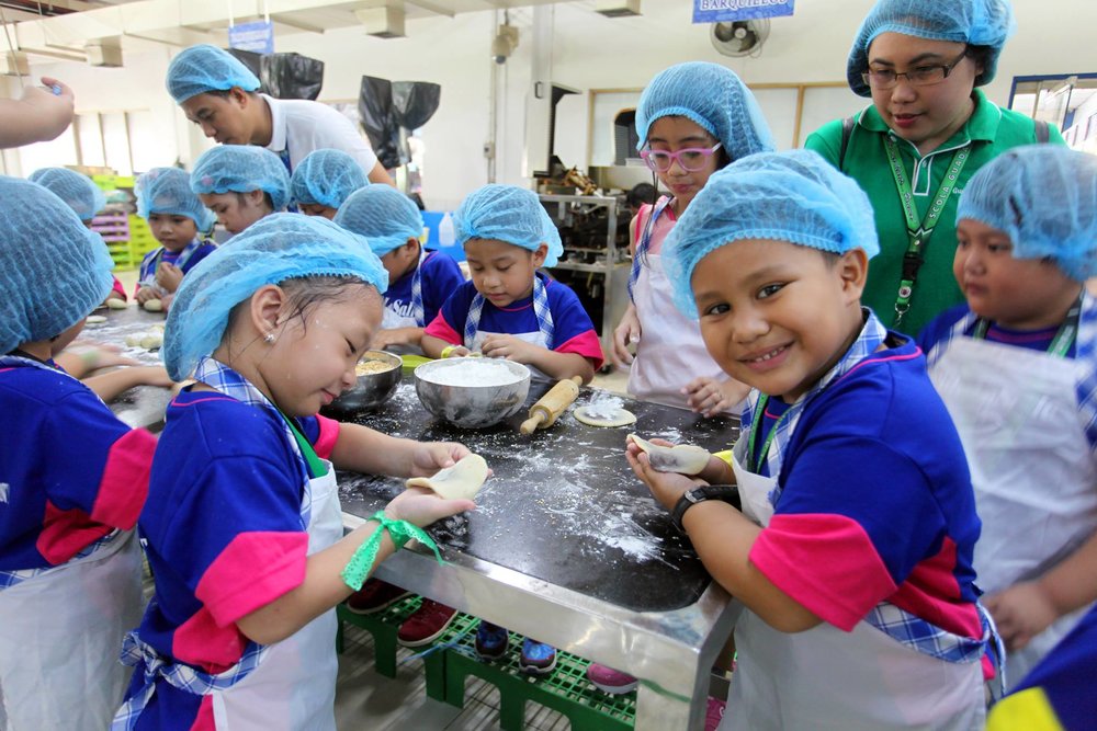 Kids learning how to make bread in a tour