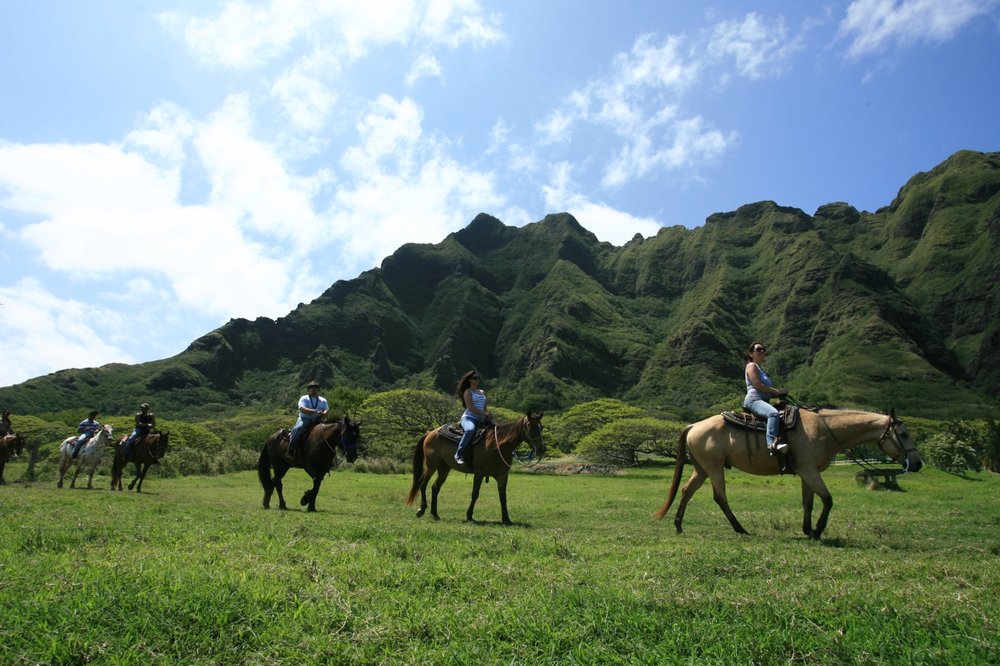 Visitors horseback riding at Kualoa Ranch