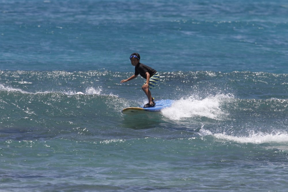 Kid surfing on Waikiki Beach's waters