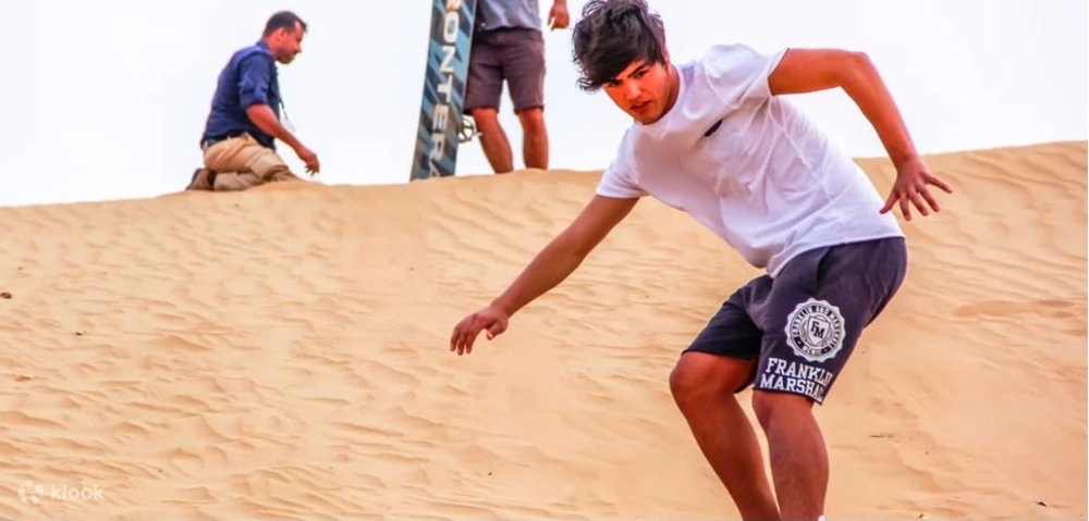 A guy sand surfing