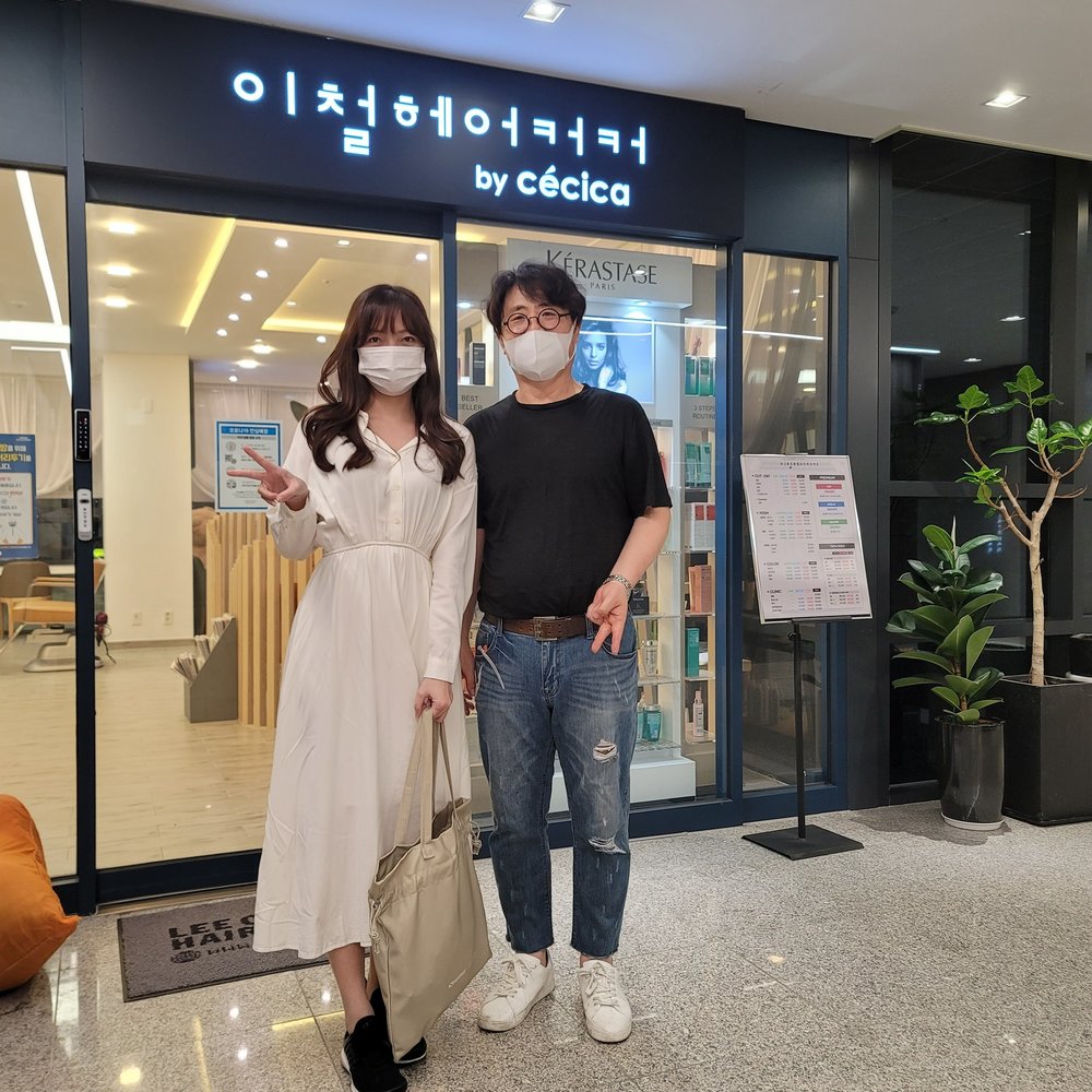 Two people standing in front of the salon