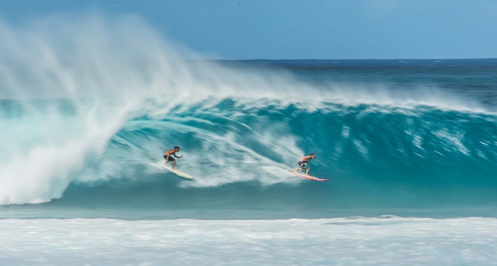 two guys surfing in haleiwa oahu