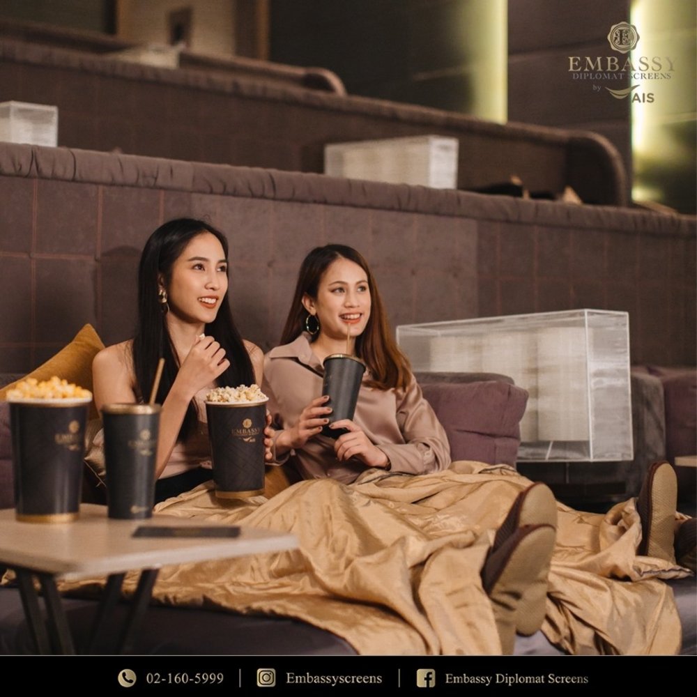 Two girls watching while eating popcorn