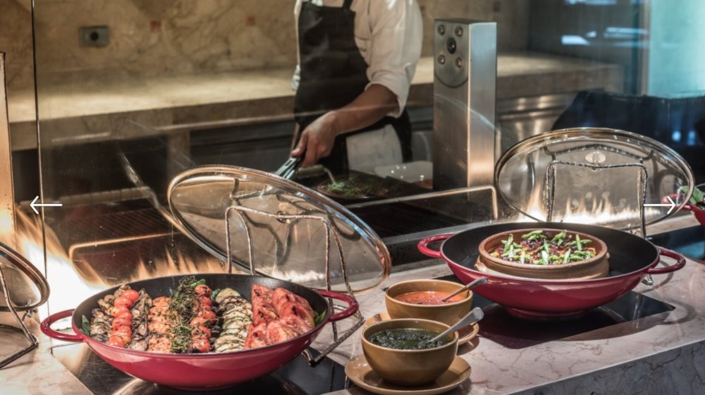 Chef opening a wok with a shrimp dish