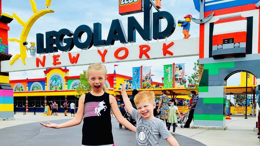 Kids happily posing for a photo at the entrance of LEGOLAND New York