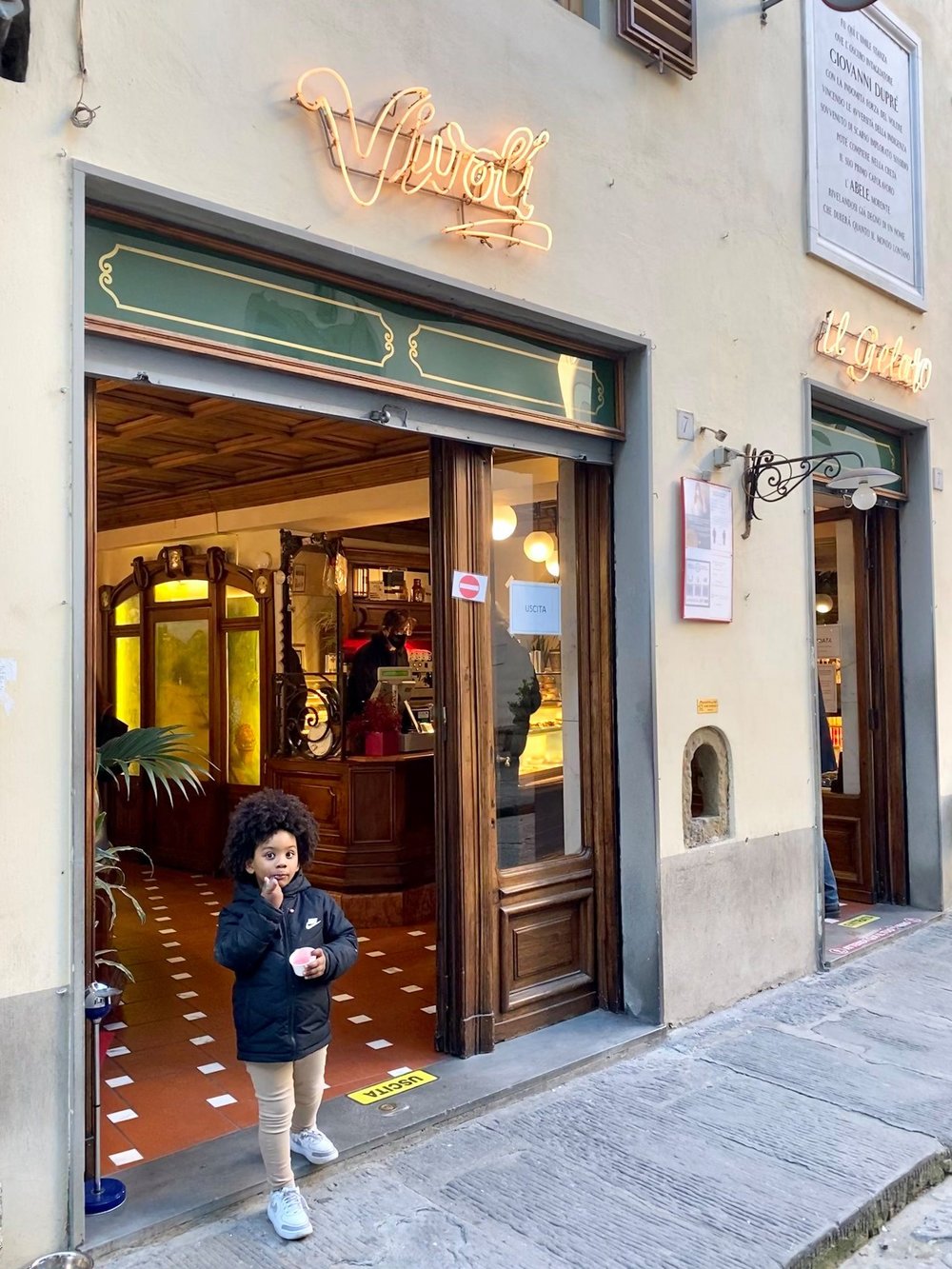 Kid standing in front of an ice cream shop