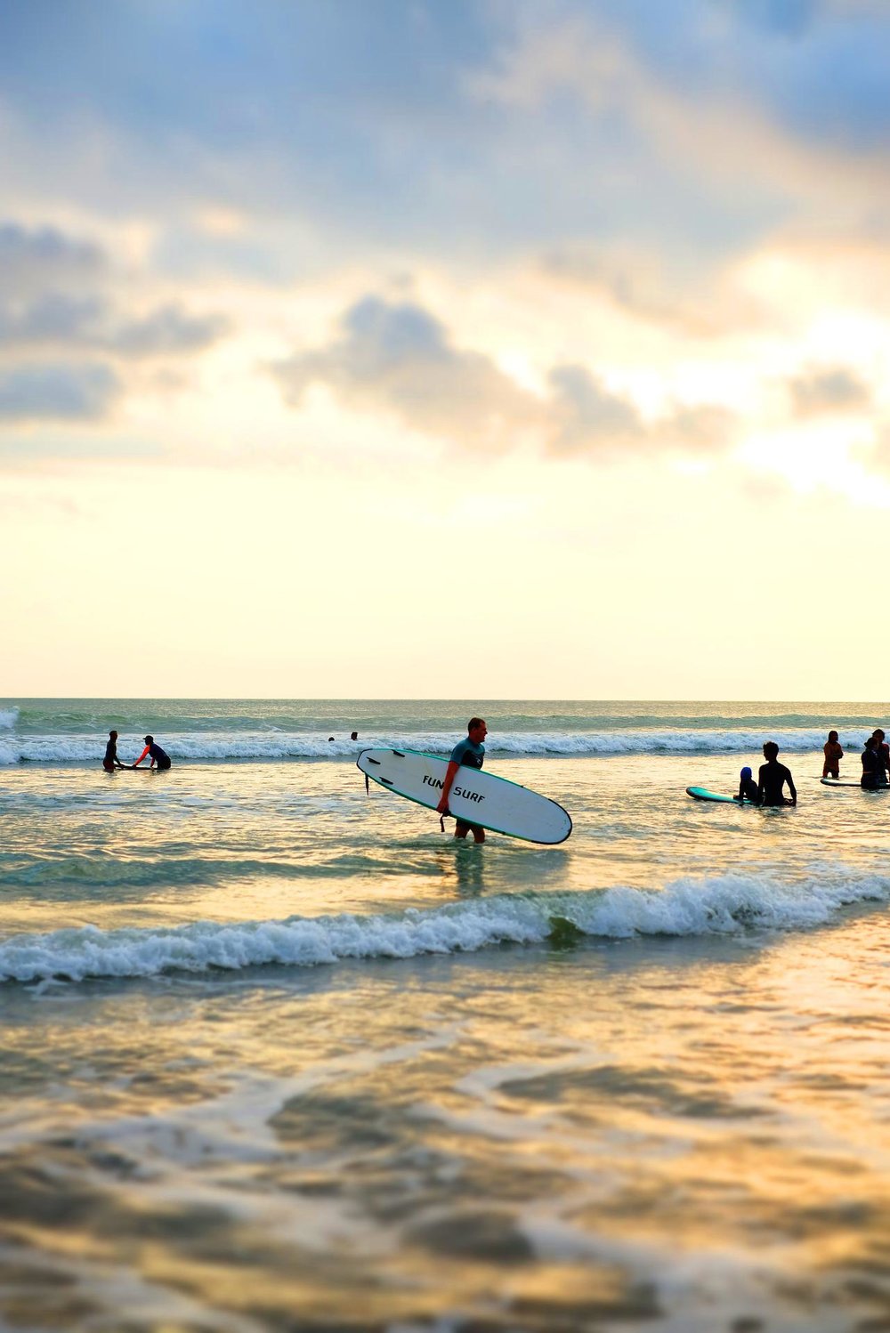 Surfers in the beach in sunset