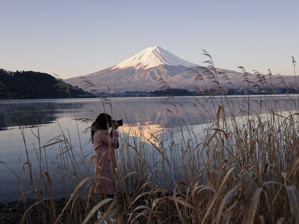 Woman taking a photo with Mt. Fuji as her background