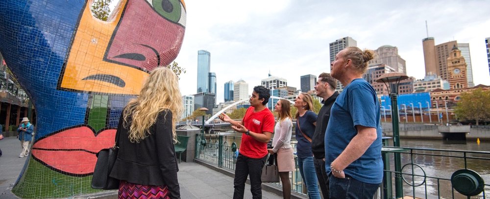 Tour guide explaining an art piece during the Melbourne Bites and Sights Tour