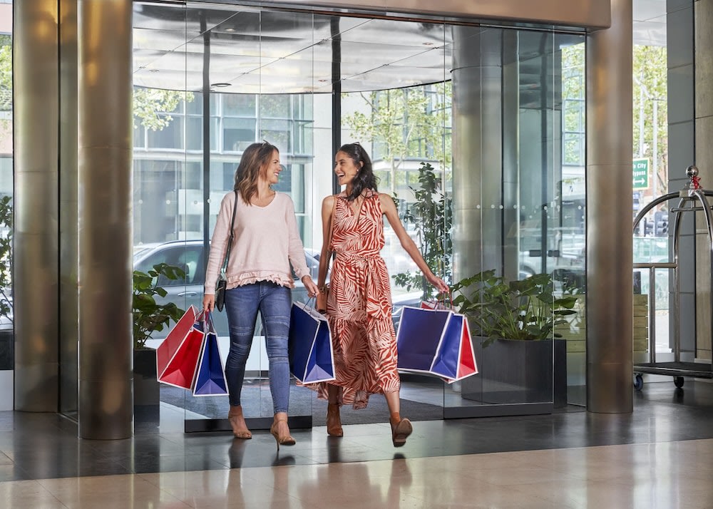 Two women entering the Melbourne Marriott Hotel with shopping bags
