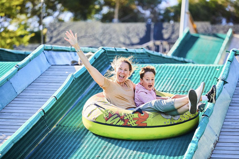 Parent and kid having fun on a slide in Enchanted Adventure