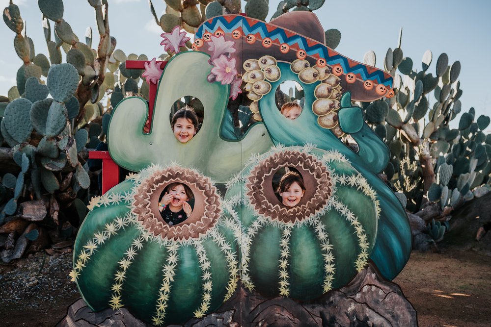 Kids posing for a photo with cactus decorations