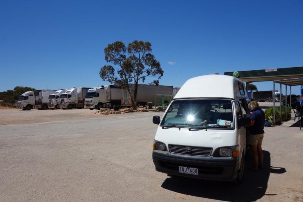 the Caiguna Roadhouse along Eyre Highway, a person is checking the car out from the driver's seat area