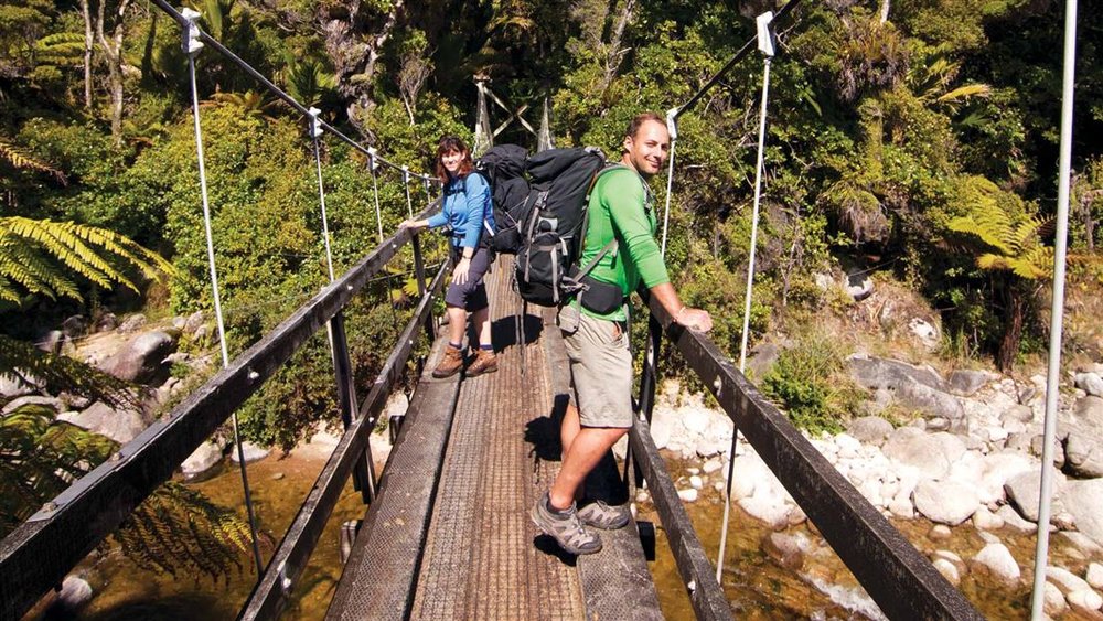 Hiker posing in a hanging bridge in New Zealand