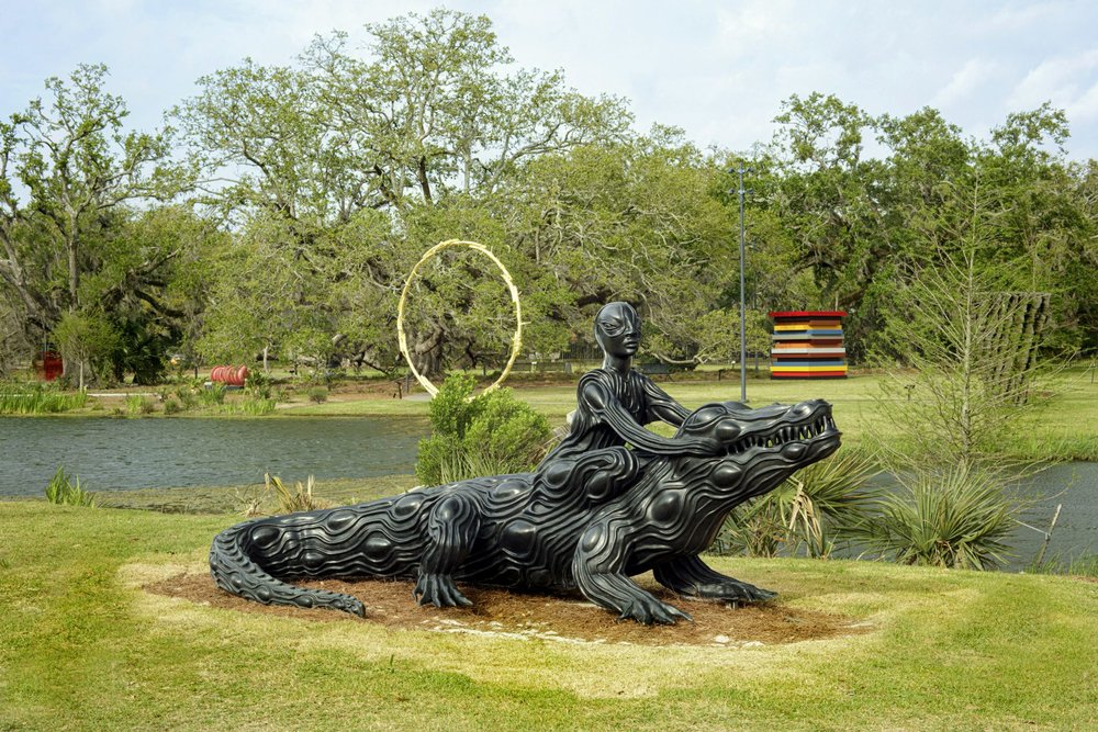Man riding a crocodile statue in New Orleans Museum of Art