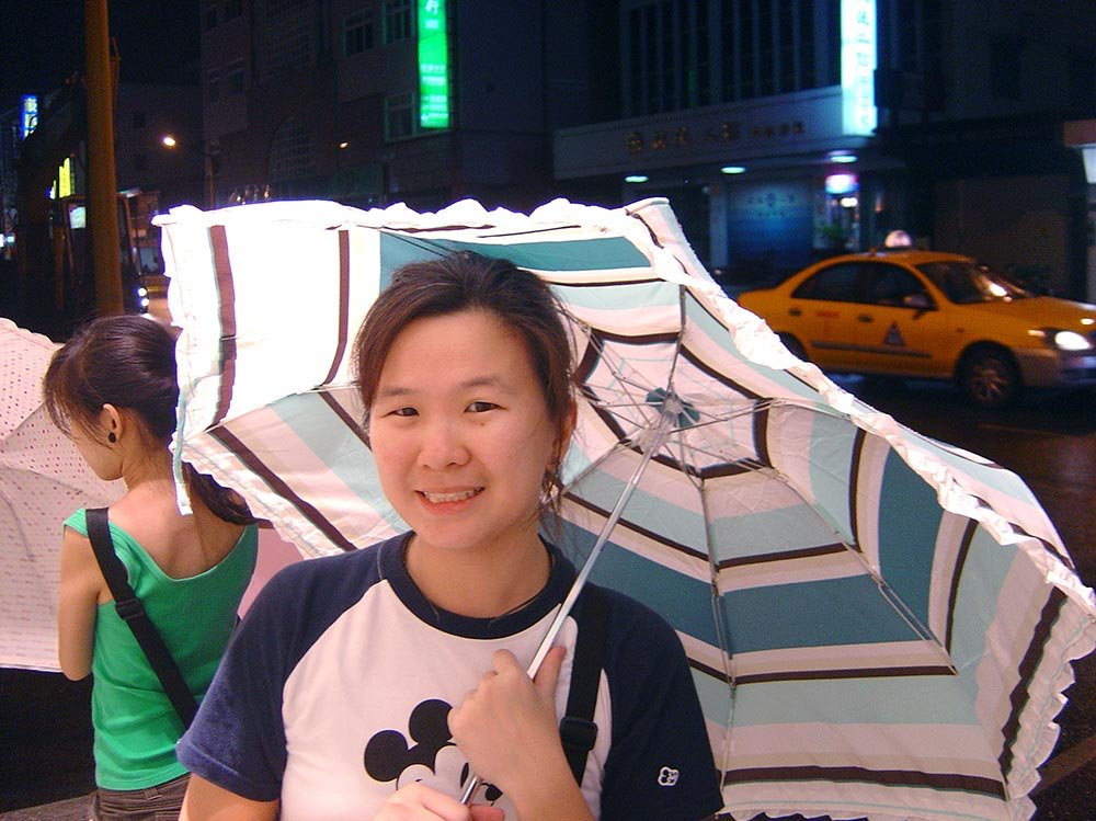 Lady posing for a photo while holding an umbrella