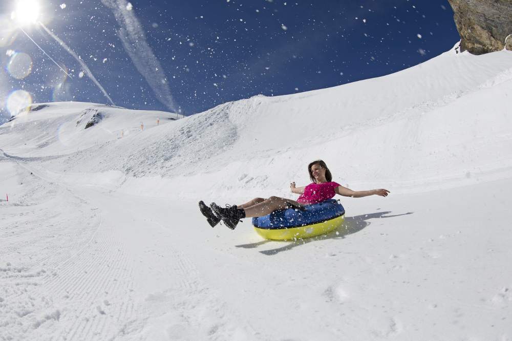 a woman on a sliding tube on a snowy area in Mount Titlis Switzerland