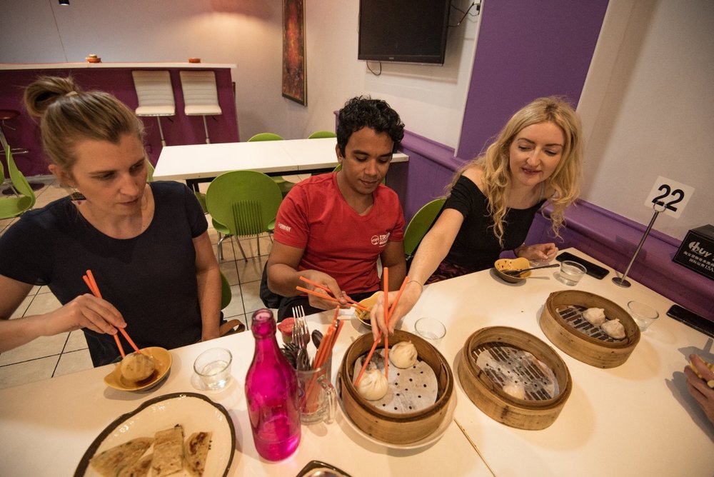 people and a guide enjoying dumplings in melbourne 