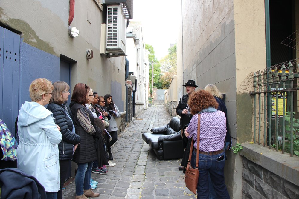 people exploring the Fitzroy suburb with a tour guide to learn about true crime
