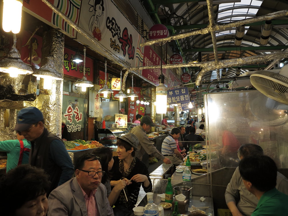 People buying and eating from different stalls at Dongdaemun
