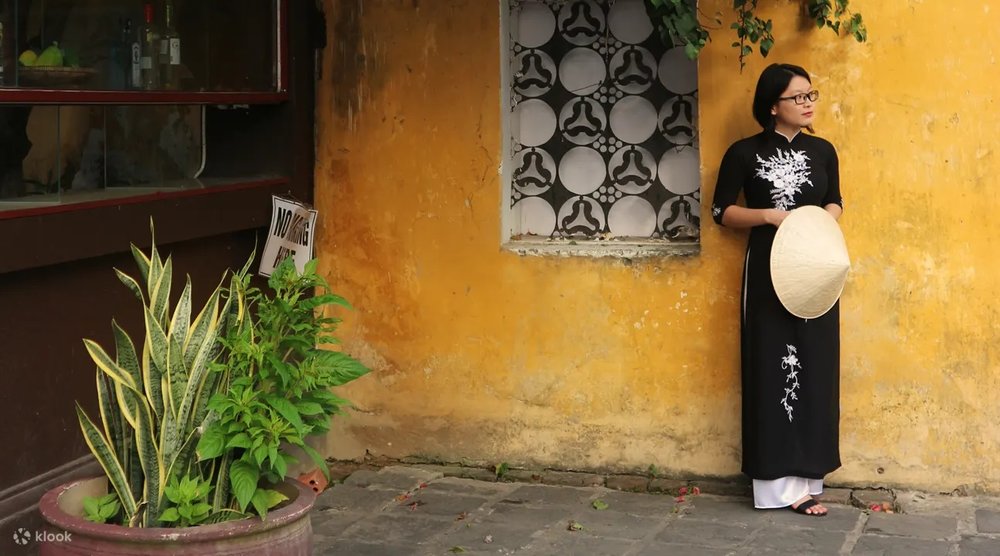 ใส่ชุดอ่าวหญ่ายสีดำ ถ่ายกับกำแพงสีมัสตาร์ด เด่นมาก 