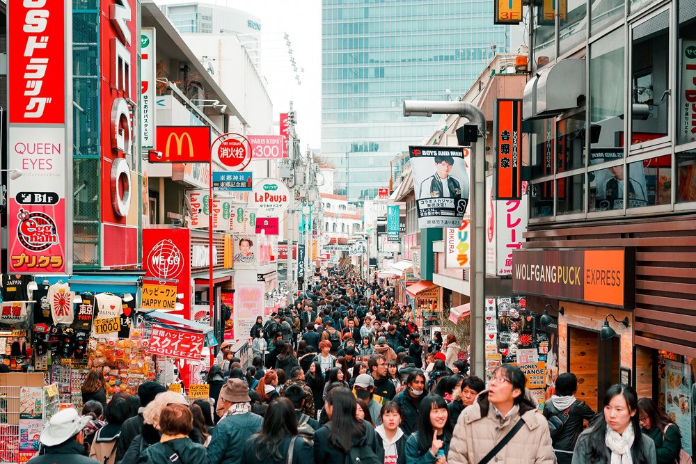 a massive crowd walking along a street in Harajuku
