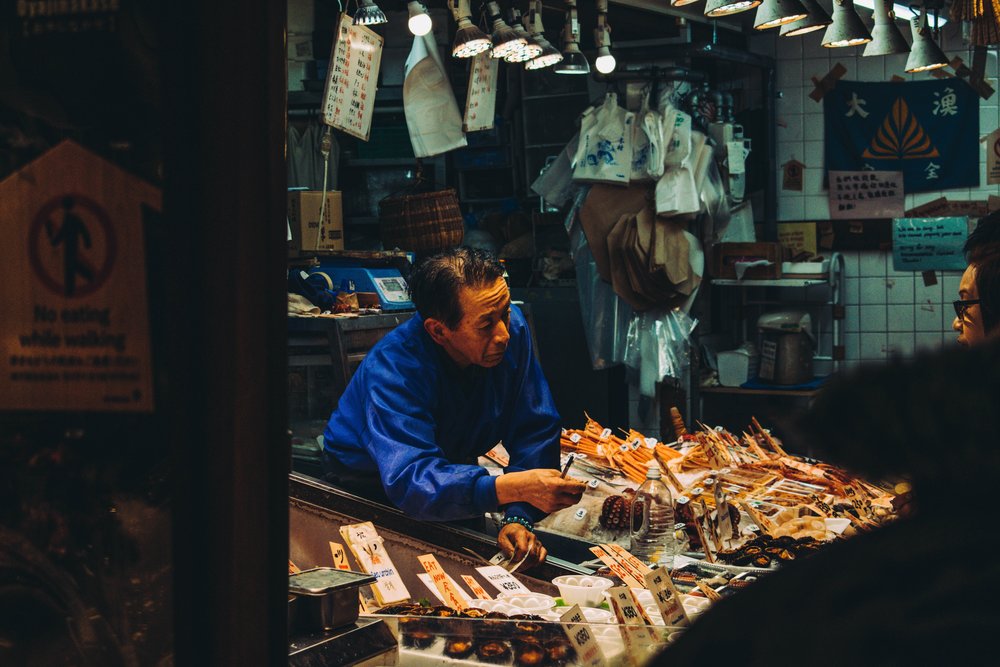 a person selling food at Nishiki Market