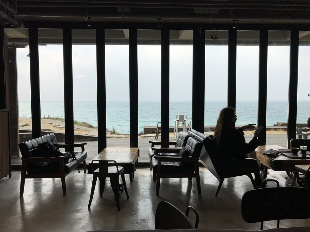 Lady sitting on a chair beside empty tables and chairs