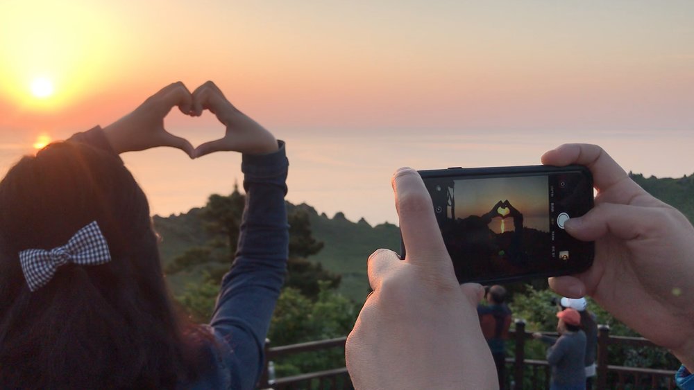 Girl making a heart with her hands for a photo