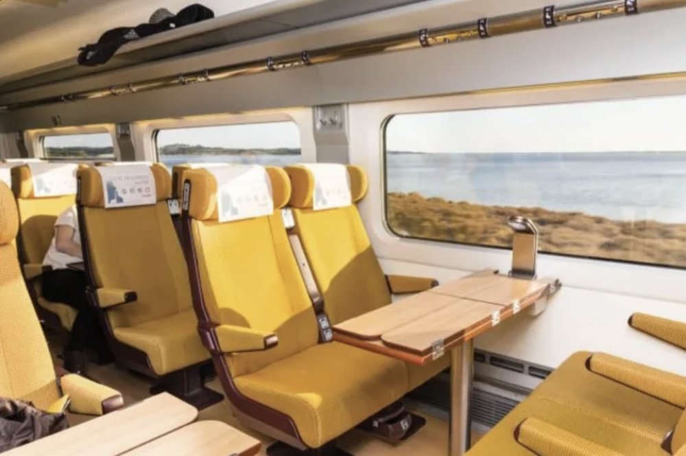 Yellow seats and wooden tables inside the train