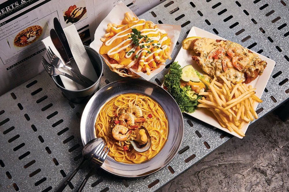 Fries and pasta dish in table