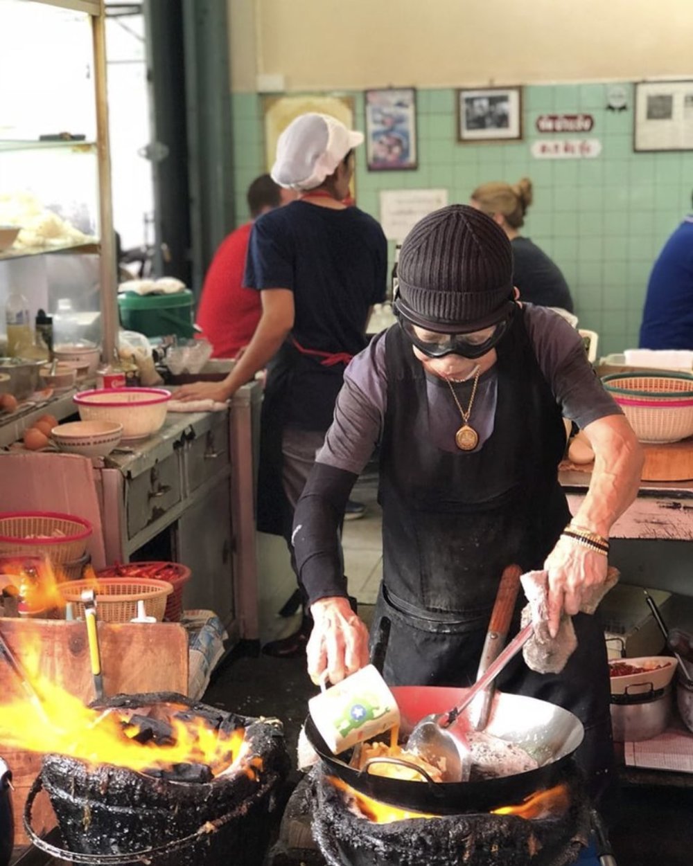 Chef cooking and people and kitchen in the background