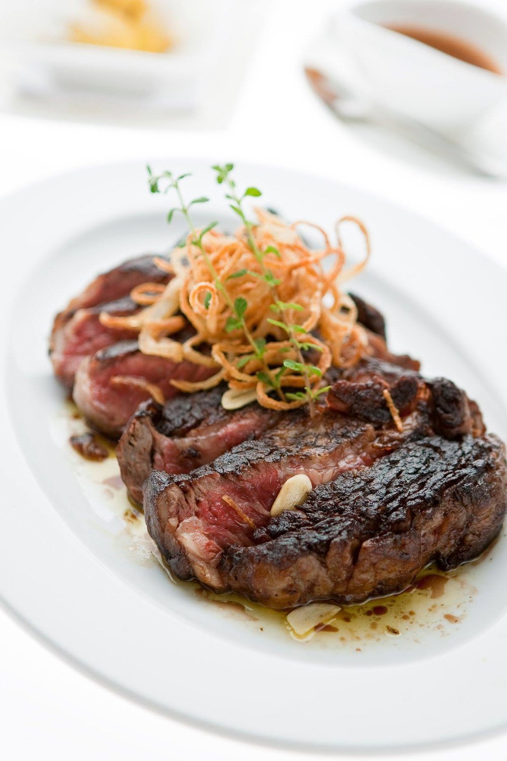 Steak with fried noodles on top with mint