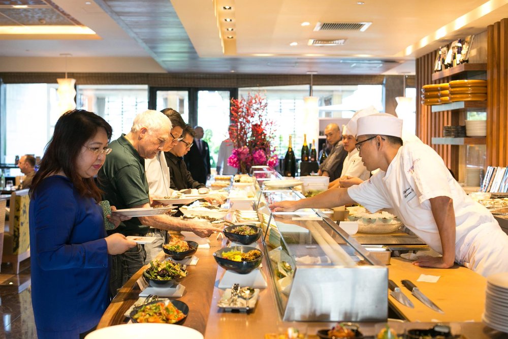 Chef serving customer in buffet table