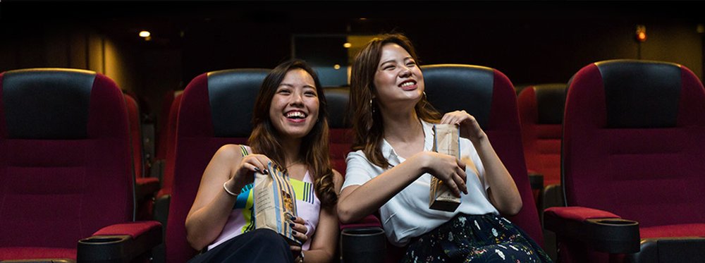 Girls laughing while watching a movie