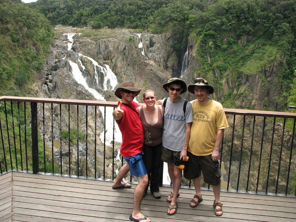 People smiling for a photo in front of a waterfall