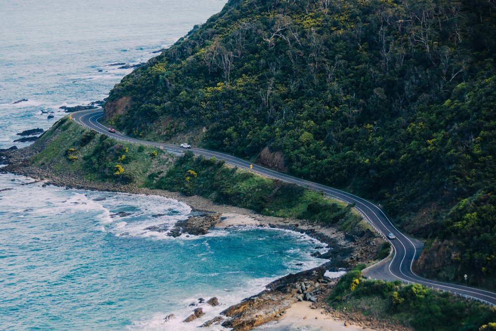 A road in between forests and the sea