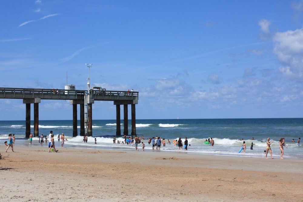 People walking and swimming on the beach