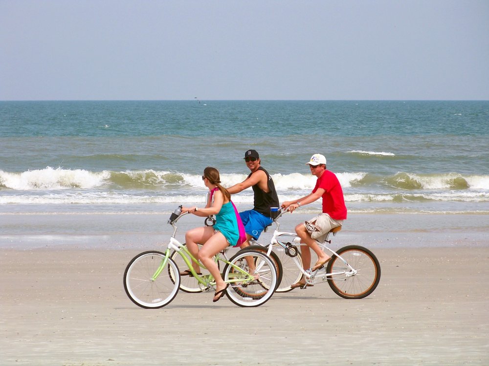 People happily biking on the beach