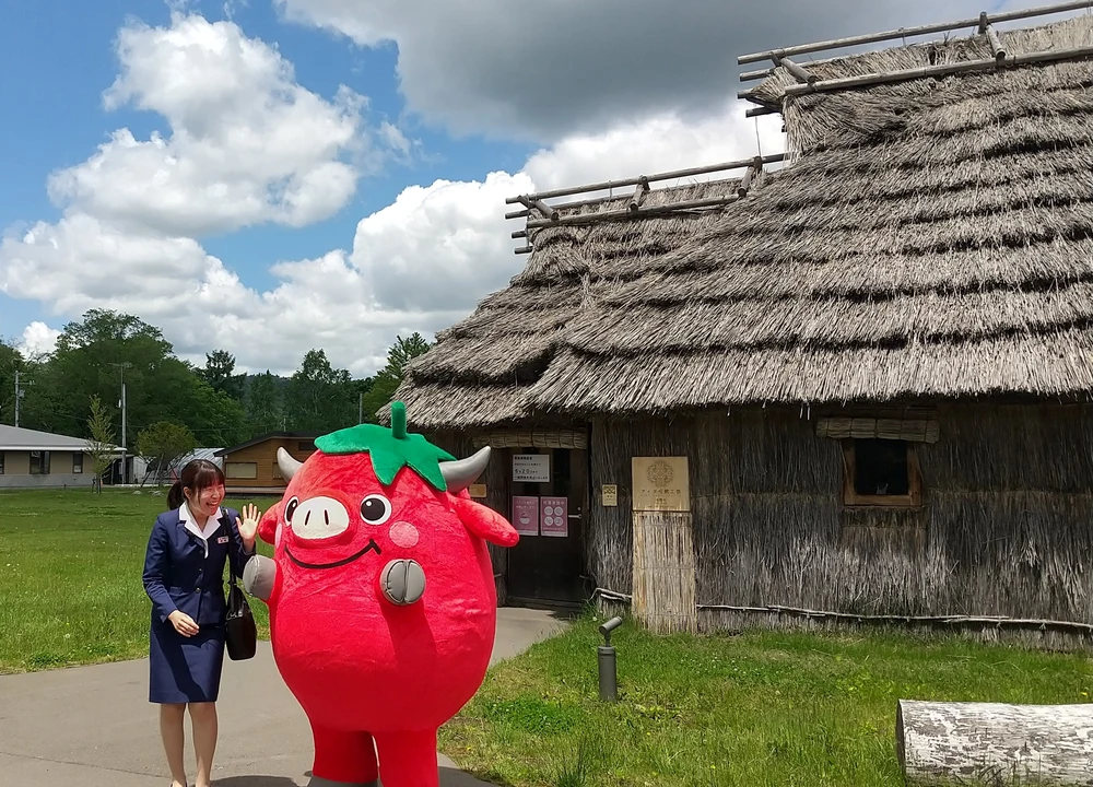 Lady smiling for a photo with a red mascot