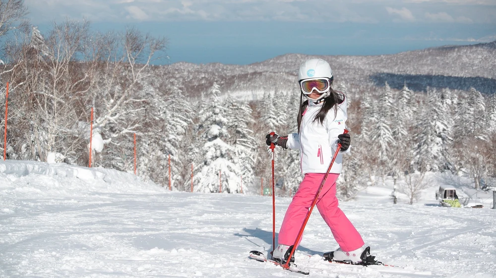 Girl wearing pink and white getting ready to ski