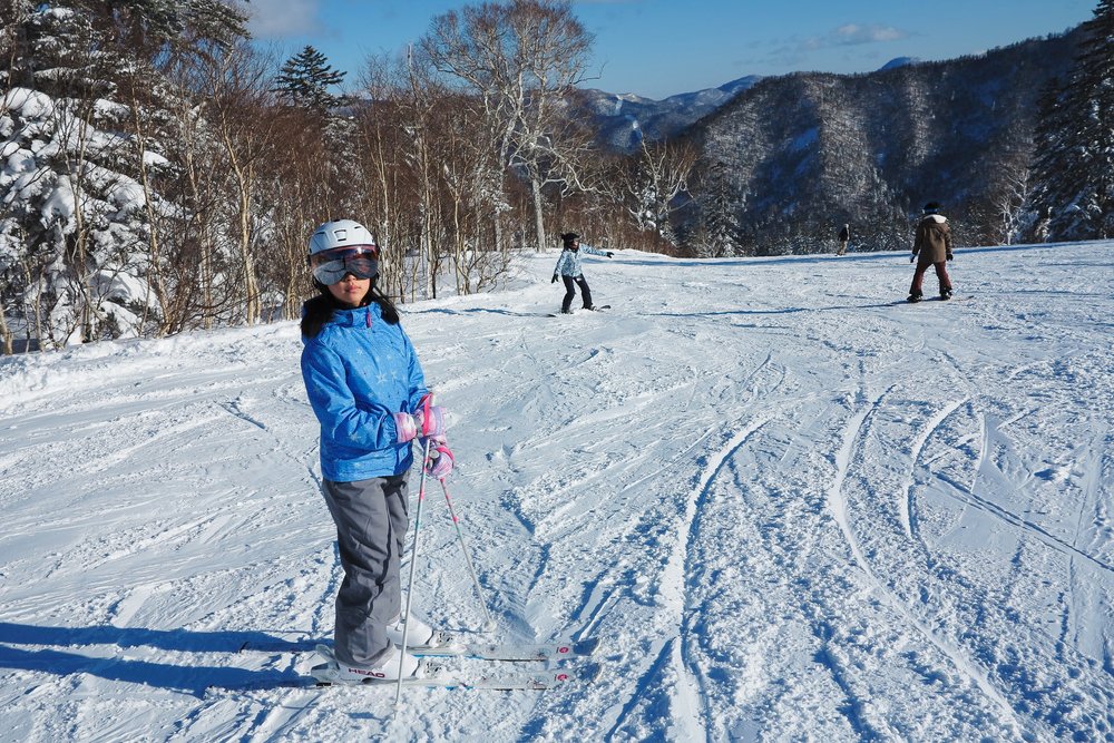 Kid in blue getting ready to ski in the snow