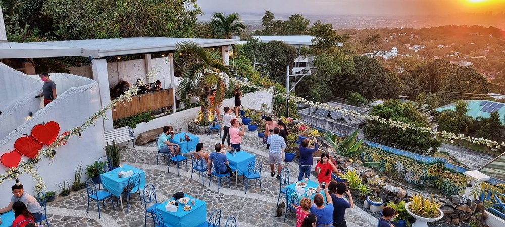 People dining in a cafe while watching sunset