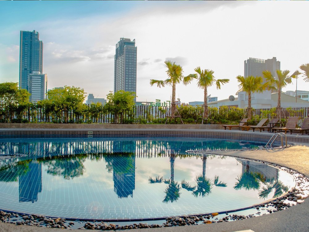 Pool surrounded by buildings and palm 