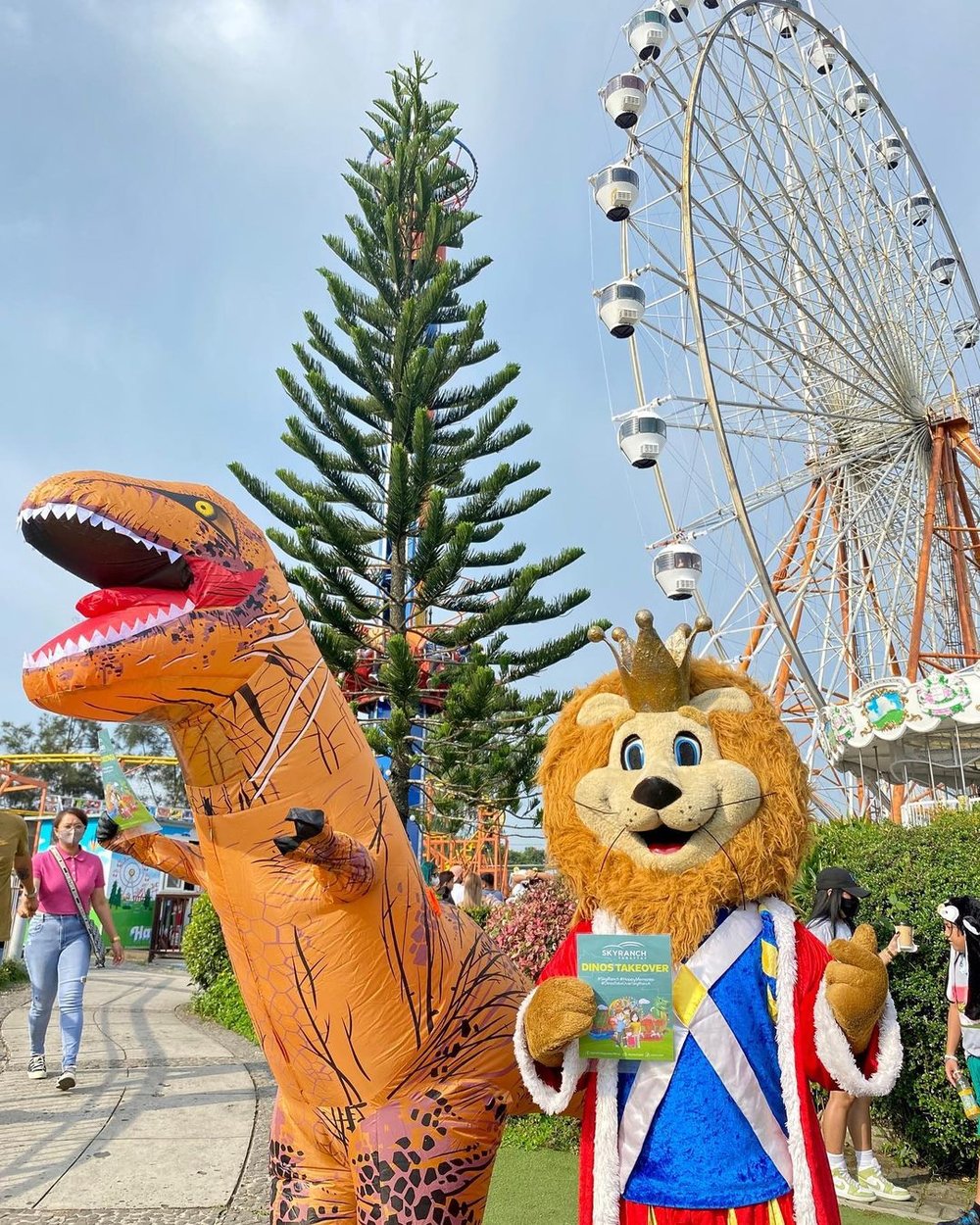 A dinosaur and lion cosplayer