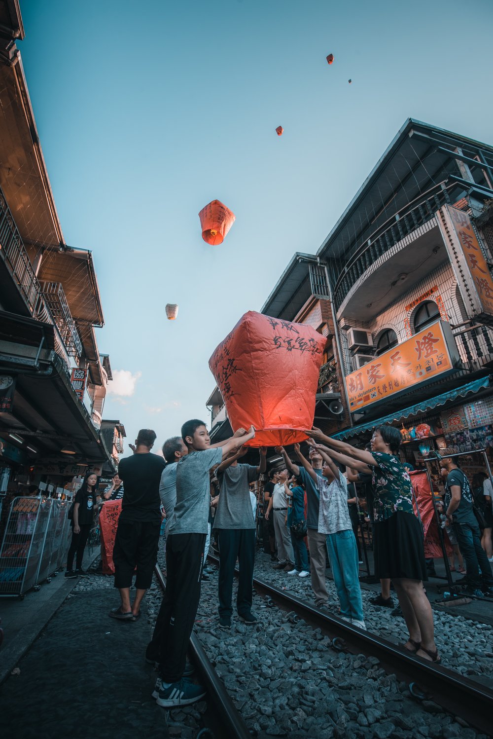 A family ready to let their orange lantern float up in the air