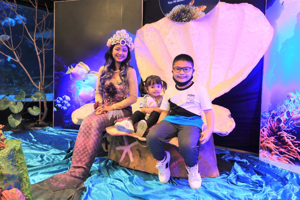 Kids posing together with a mermaid