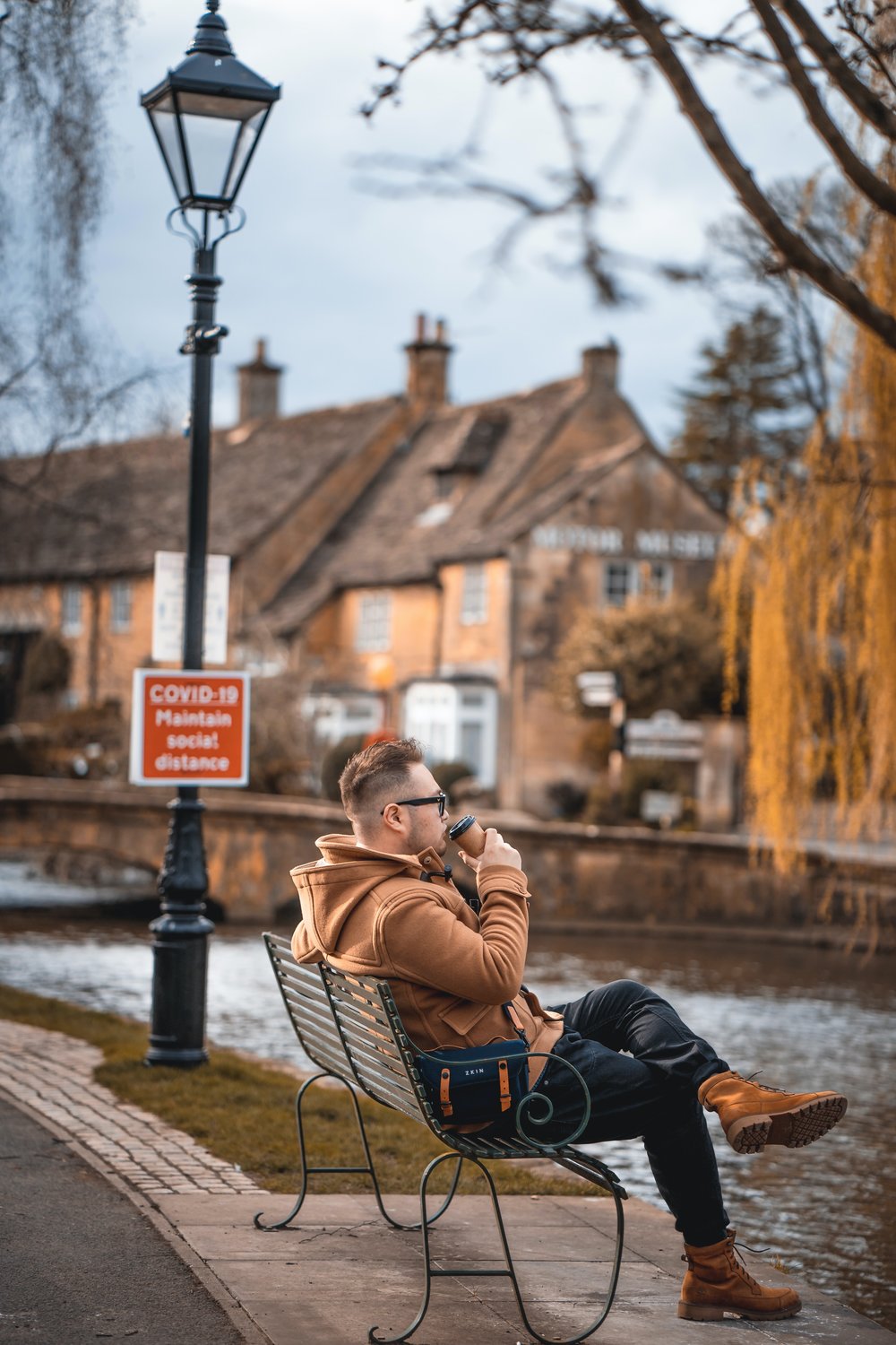 Man sitting on a bench while sipping his drink 